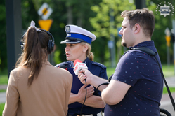 Na zdjęciu policjantka rozmawia z dziennikarzami podczas konferencji prasowej.