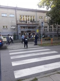 policjanci kontrolują zachowanie kierowców w rejonie przejść dla pieszych przy szkole