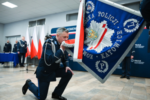 Zdjęcie przedstawia Komendanta Wojewódzkiego Policji w Katowicach całującego sztandar.